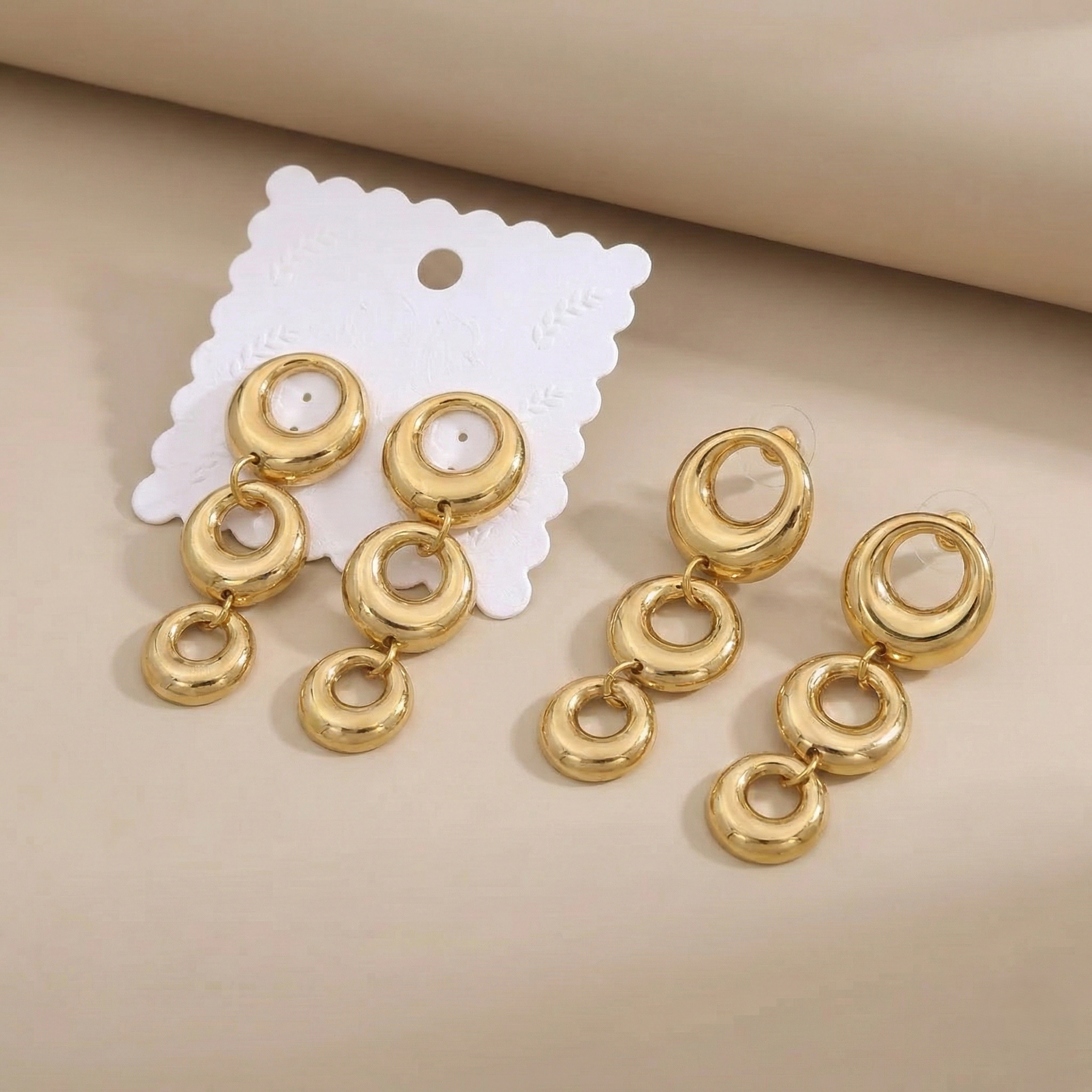 Triple-linked circular drop with a high-shine finish.