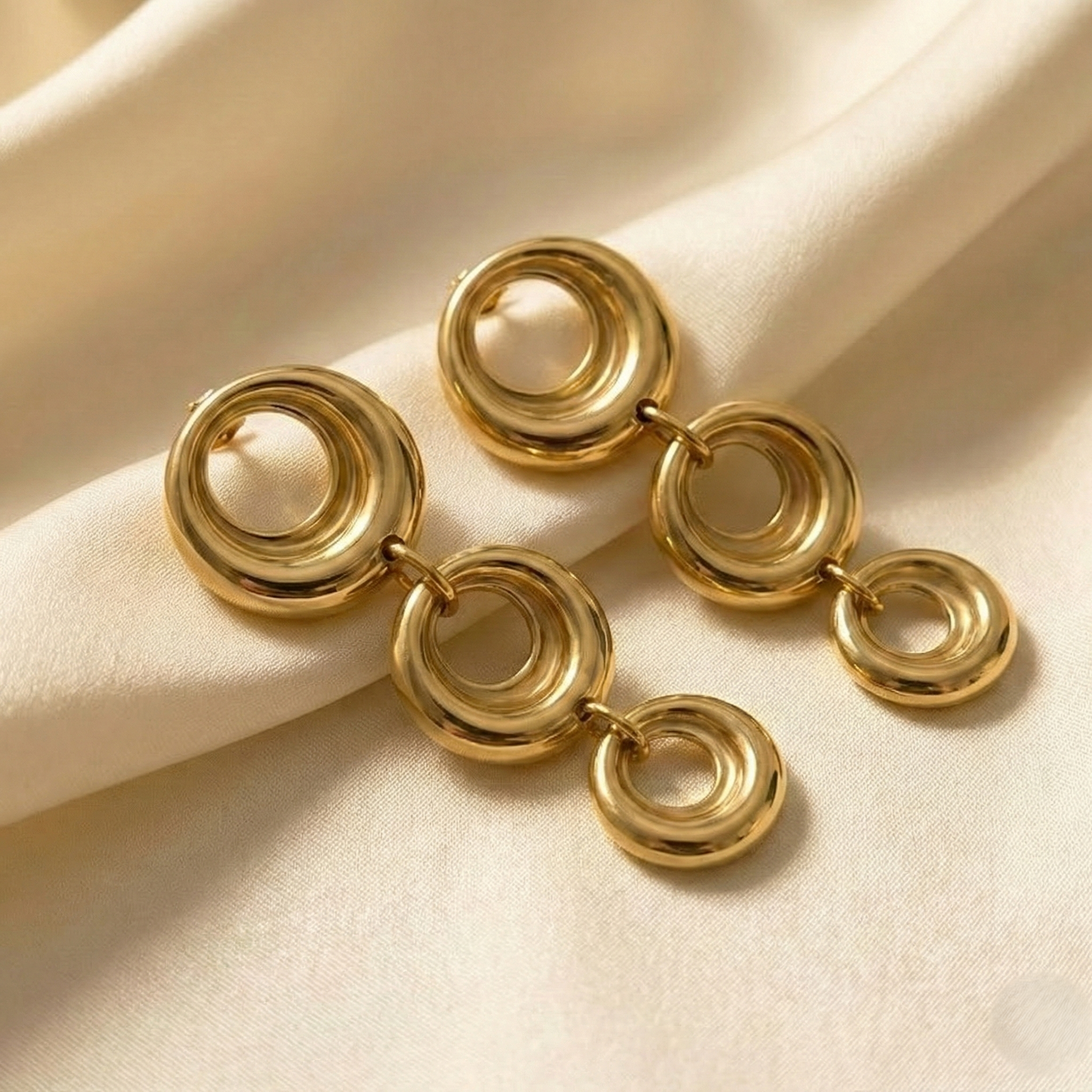 Triple-linked circular drop with a high-shine finish.